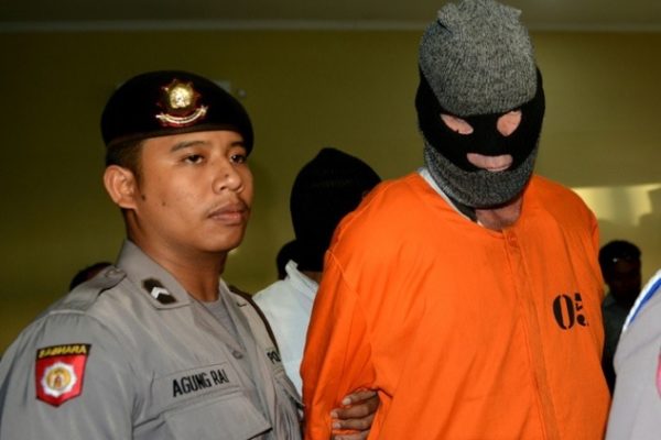 Wearing a balaclava and orange monkey suit, I'm forced to face the media at a news conference three days after my arrest.